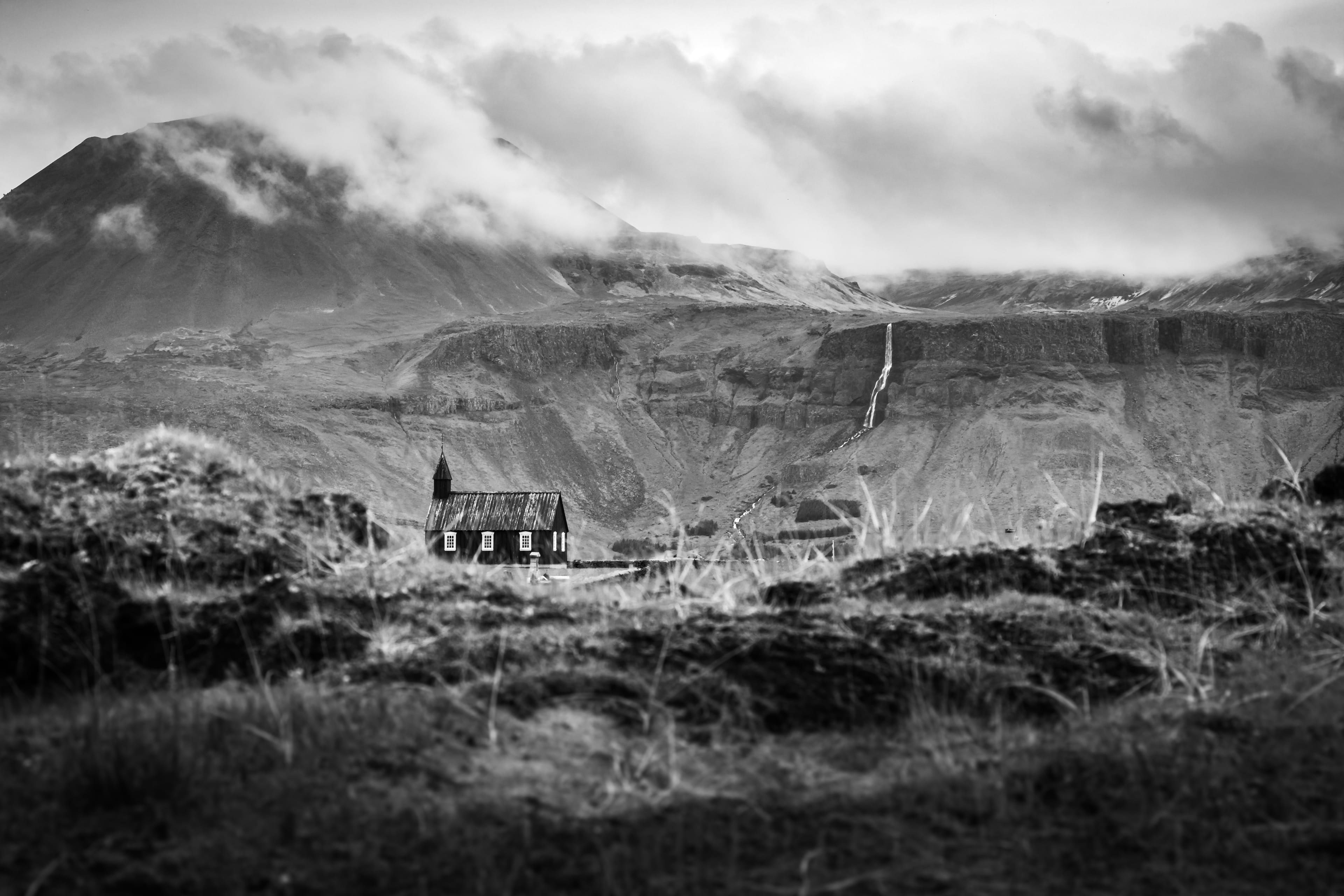 Ruine de bergerie isolée au fond d’une vallée, en noir et blanc, les sommets noyés dans les nuages